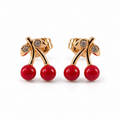PM137G - Gold Twin Red Cherry Sparkle Leaf Stud Minđuše od hirurškog čelika, zlatne minđuše sa po dve sjajne crvene trešnje, zakrivljenim drškama, svetlucavim listićima i stud zatvaračima na beloj pozadini