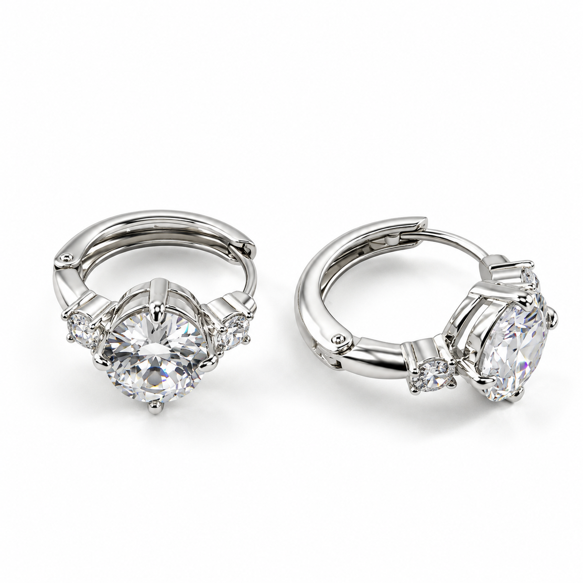 PM194 - Silver Round-Cut Three-Stone Prong Huggie Minđuše od hirurškog čelika, par srebrnih obruča sa krupnim prozirnim okruglim kamenom u izdignutoj metalnoj postavci i dva manja bočna kamenčića na beloj pozadini