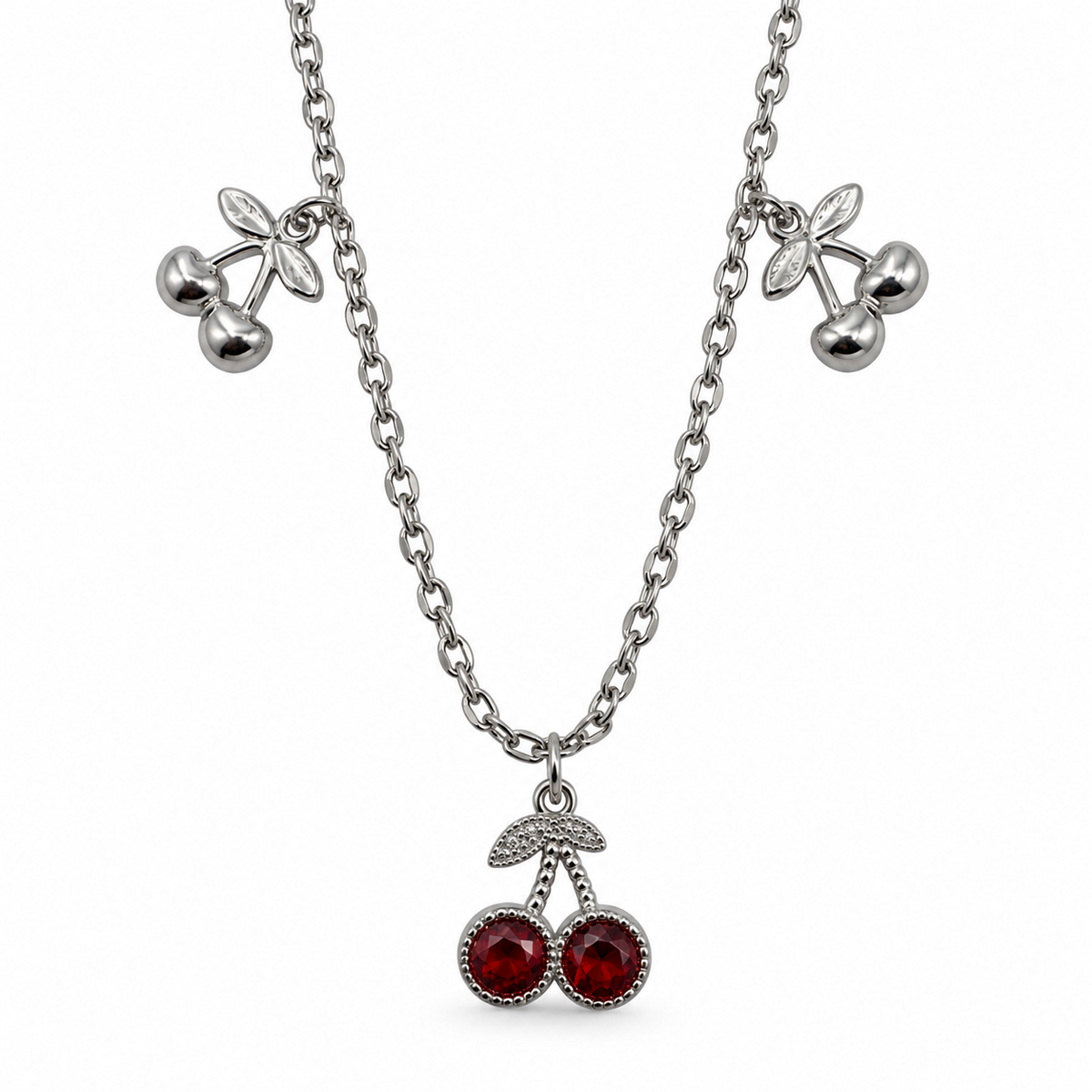 PO069 - Silver Triple Cherry Charm Red Accent Ogrlica, krupan prikaz dva bočna srebrna motiva trešanja sa listićima i centralnog priveska sa dve fasetirane crvene dekoracije u srebrnim okvirima, na beloj pozadini